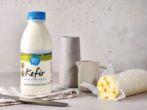 Kefir Blue cheese with an American waxed rind, marbled blue veins, and a rich, tangy profile. Served with rye bread, figs, and honey on a marble slab, highlighting its bold and aged characteristics